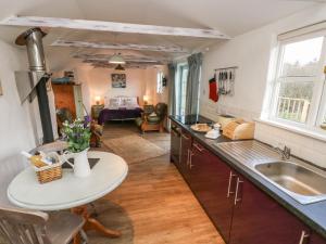 a kitchen and living room with a table and a sink at Five Elements Studio in St. Agnes