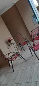 two chairs and a table with flowers in a room at Recanto Jurandir Marçal in Olímpia