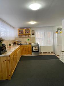 a kitchen with wooden cabinets and a white refrigerator at Pensiunea Maria in Lacu Rosu +25 photos