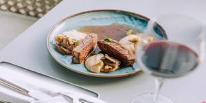 a plate of food with meat and a glass of wine at InterContinental Cascais-Estoril by IHG in Estoril