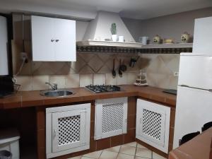 kuchnia z białymi szafkami i zlewem w obiekcie Apartamento en sanxenxo duplex w mieście Sanxenxo