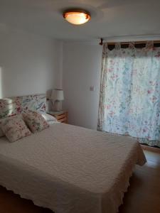 1 dormitorio con cama y ventana en Apartamento en sanxenxo duplex, en Sanxenxo