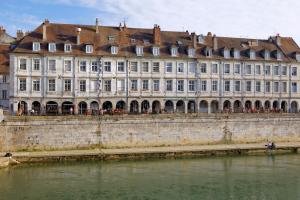 a large building next to a body of water at LA DOLCEVITA SPA Chambre privative in Besançon