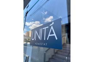 a sign in the window of a building at Flat Unitá Homestay in Praia Grande