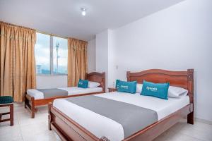 a bedroom with two beds and a window at Ayenda Gold Plaza in Ibagué