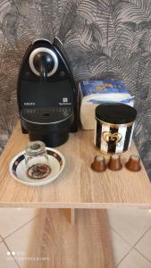 a table with a coffee maker and a plate of food at Superbe appartement au rez-de-chaussée avec clim mobile,parking et wifi gratuit in Casablanca