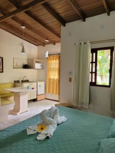 a bedroom with a bed with a flower on it at Pousada Mares do Santinho in Florianópolis