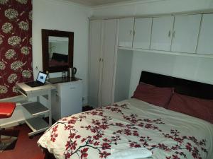 a bedroom with a bed and a desk and a mirror at Private Cosy Roomz in London