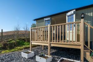 a mobile home with a deck and some plants at Scalderskew Shepherds Hut in Gosforth