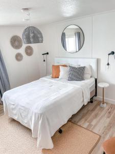 una camera da letto con un grande letto bianco e uno specchio di Bryce UpTop Lodge a Bryce Canyon