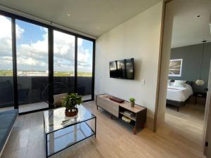 un soggiorno con letto e una camera con tavolo di Brand New Condo with Rooftop Pool a Cozumel Altre 39 foto