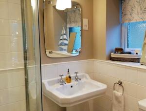 a bathroom with a sink and a shower and a mirror at Juliet Cottage, late Georgian treasure, charming, cosy and historic, only a short walk to Alnwick Castle in Alnwick +21 photos