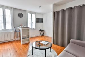 ein Wohnzimmer mit einem Sofa und einem Tisch in der Unterkunft LE COCON #Centre ville #100m de la Charente in Cognac