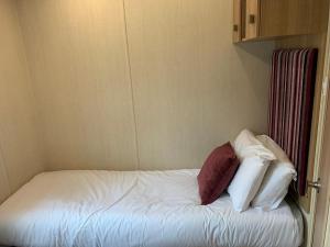 a bed with three pillows on it in a room at Hoburne Devon Bay Paignton L48 in Paignton