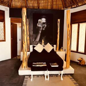 a bedroom with a bed with a poster on the wall at Cabañas Sicarú Mazunte in Mazunte