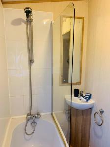 a bathroom with a shower and a tub and a sink at Hoburne Devon Bay Paignton L48 in Paignton