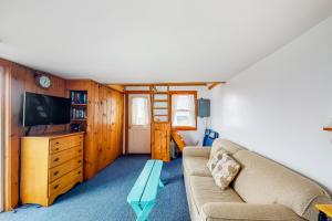 sala de estar con sofá y TV en Dream Harbor Cottage en Surry