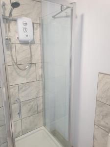 a shower with a glass door in a bathroom at Garden Room in Northolt