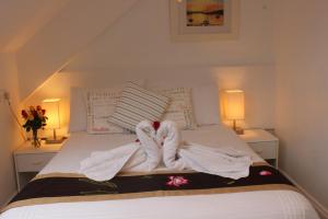 a bedroom with two towels on a bed at Silver Birch in Looe