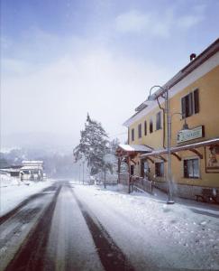 una calle cubierta de nieve en una ciudad con un edificio en B&B Al Cavaliere, en Lorica