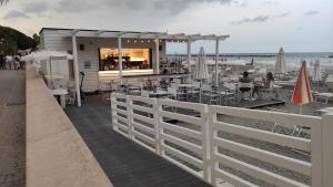 a restaurant on the beach with tables and chairs at Hotel Fortuna in San Bartolomeo al Mare