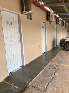 a garage with three doors and a car parked in it at Porto Seguro Hotel - Porto Velho in Porto Velho