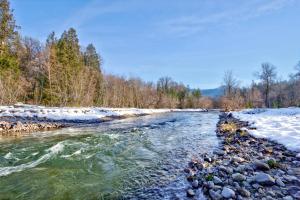 einen Fluss mit Schnee am Ufer in der Unterkunft Waterfront Cabin at White Pass and Mount Rainier National Park in Packwood