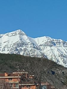 una montagna innevata di fronte a un edificio di Casa Guerrino a L'Aquila