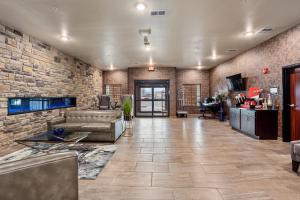 a living room with a couch and a brick wall at Cobblestone Hotel & Suites - Little Chute in Little Chute