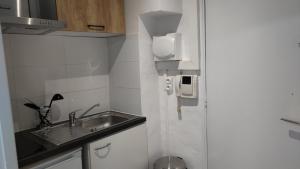 a small kitchen with a sink and a phone at Appartement 5 - tout équipé - Carmes, Toulouse in Toulouse