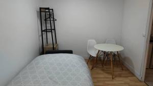 a bedroom with a bed and a table and chairs at Appartement 5 - tout équipé - Carmes, Toulouse in Toulouse