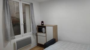 a bedroom with a bed and a microwave on a shelf at Appartement 5 - tout équipé - Carmes, Toulouse in Toulouse