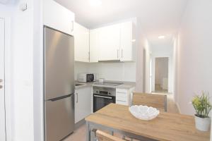 een keuken met een koelkast en een houten tafel bij Apartamento recién reformado en el centro de Nerja in Nerja