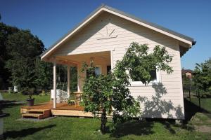 a small white shed with a deck and a table at holiday home, Kolczewo in Kołczewo