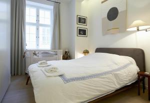 ein Schlafzimmer mit einem weißen Bett und Handtüchern darauf in der Unterkunft ApartmentInCopenhagen Apartment 1476 in Kopenhagen