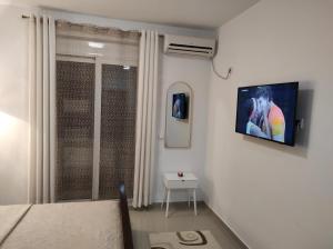 a room with a tv on a wall with a window at Guest House AGA in Ulcinj