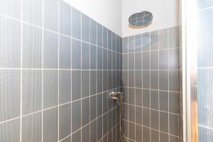 y baño con ducha y paredes de azulejos grises. en Baretti House 2 - Colazione offerta a ogni soggiorno, en Turín 17 fotos más