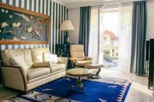 ein Wohnzimmer mit einem Sofa und einem Stuhl in der Unterkunft Boutique Hotel Joli Bois in De Haan