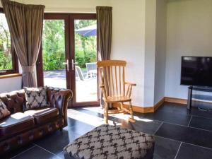 un soggiorno con divano, sedia e TV di Little Chestnut a Muir of Ord