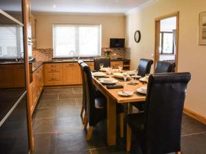 a dining room table with chairs and a kitchen at Little Chestnut in Muir of Ord