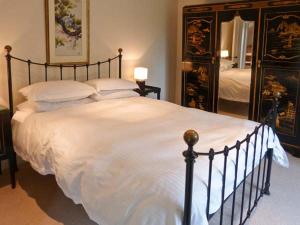 a bedroom with a large bed with white sheets and pillows at Easter Urray Farmhouse in Muir of Ord