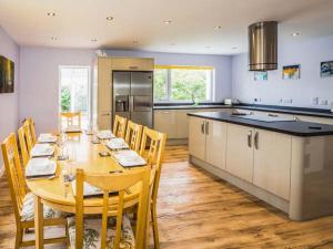 a large kitchen with a wooden table with chairs and a large kitchen withuclear at Tigh Na Sith in Aultbea