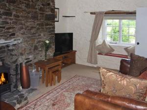 a living room with a couch and a fireplace at Tuckermarsh Quay River Cottage 2 in Bere Alston