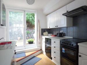 a kitchen with a stove and a window in it at Tidewood in Polzeath