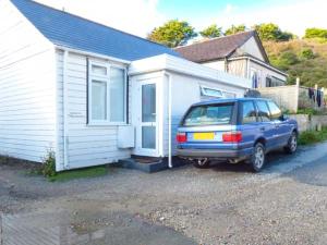 a blue car parked in front of a house at Tidewood in Polzeath
