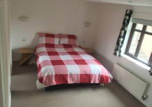 a red and white bed in a room with a window at 6 Bedroom House For Corporate Stays in Kettering in Kettering