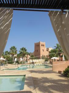 a view of the pool at a resort with a clock tower at Kasbah del Puerto Rey Precioso Bajó in Playas de Vera