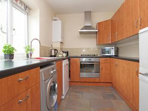 a kitchen with wooden cabinets and a dishwasher at Chy-An-Mor in Carbis Bay