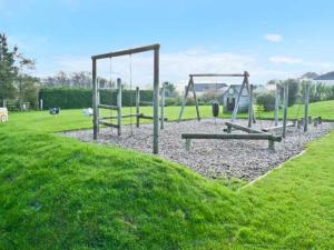 an empty playground with swings in a park at Groom Cottage in Bude