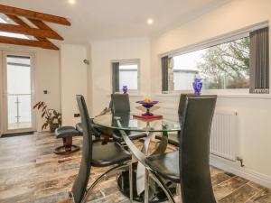 a dining room with a glass table and chairs at Chapel Green Studio 2 in St Austell